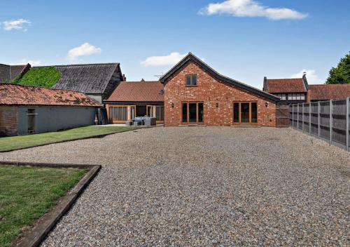 a large brick house with a gravel driveway at Barley Barn in Kimberley