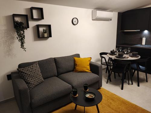 a living room with a gray couch and a table at Apartment Boras in Vir