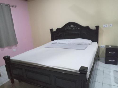 een slaapkamer met een groot bed met witte lakens bij Captivating 1-Bed Lodge in Accra in Accra