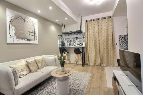 un salon avec un canapé blanc et une table dans l'établissement La Demeure des 3 Colombes, à Bois-Colombes