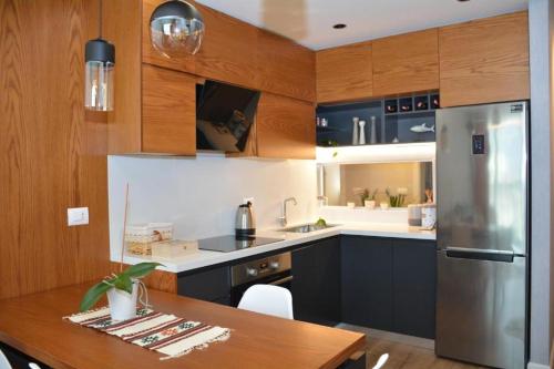 a kitchen with a table and a stainless steel refrigerator at Central Comfy Apartment in Tirana