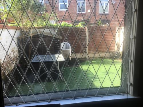 a screened in window with a chair in a yard at Double room near City Centre in Manchester