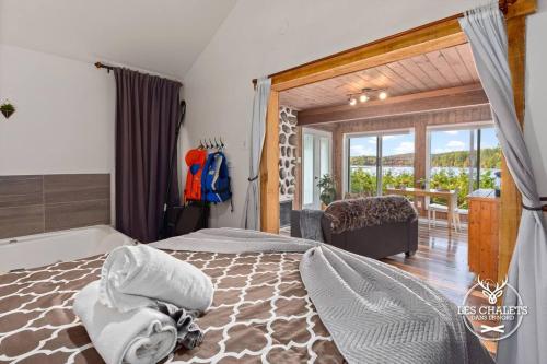 a bedroom with a bed and a room with a balcony at Le1617 - Quai privé, Lac-Les chalets dans le nord in Sainte-Lucie-de-Doncaster