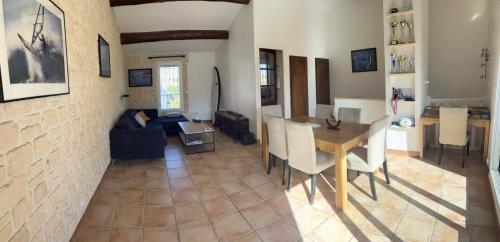 un salon avec une table et une salle à manger dans l'établissement Maison provençale (parking et vélos à disposition), au Grau-du-Roi