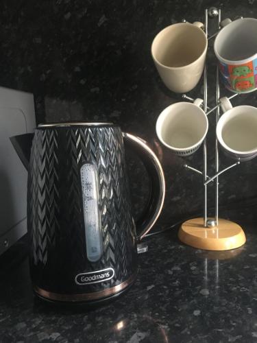 a coffee mug with a remote control in it on a counter at Double room near City Centre in Manchester