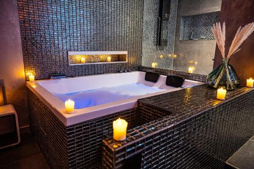 a large bathroom with a tub with candles in it at Suite Romantique in Narbonne
