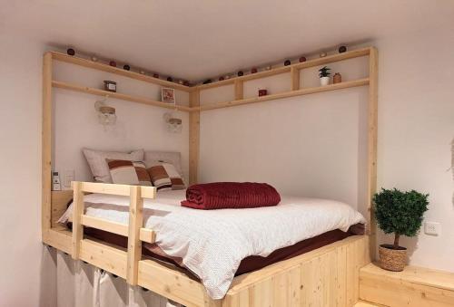 Cette chambre comprend un grand lit superposé en bois. dans l'établissement Le studio des Ambans, à Agen