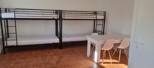 JanuszowiceにあるNoclegi u Ewusiの二段ベッド2台とテーブルが備わる客室です。