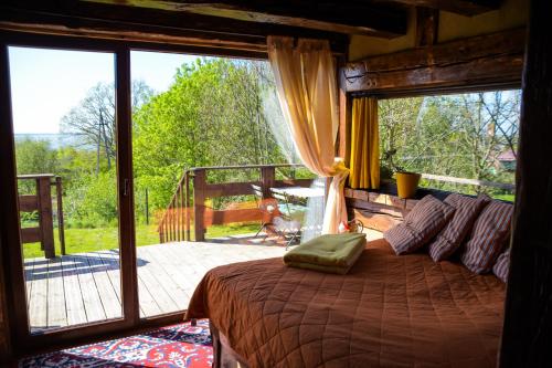 ein Schlafzimmer mit einem Bett und einem großen Fenster in der Unterkunft Ptasia Osada in Gardna Wielka