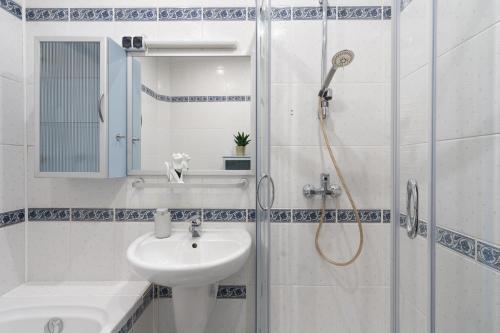 La salle de bains blanche est pourvue d'un lavabo et d'une douche. dans l'établissement Hostel Zakatek ulica Legionow, à Bielsko-Biała