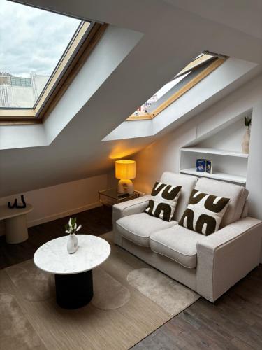 un salon avec un canapé et une table dans l'établissement Ravissant studio parisien, à Paris