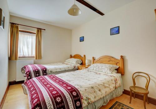 a bedroom with two beds and a chair at The Orchard in Lyng