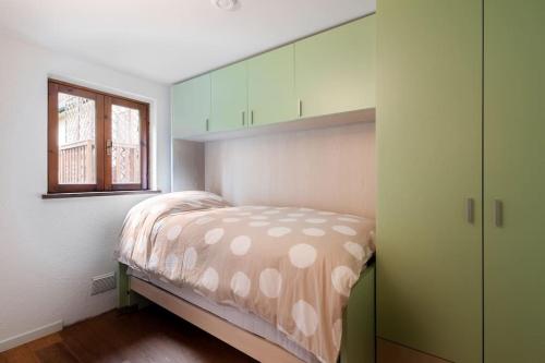 Habitación pequeña con cama y ventana en [10 min. da Courmayeur] Elegante Appartamento, en Pré-Saint-Didier