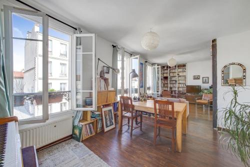 un salon avec une table et une salle à manger dans l'établissement SUPERBE DUPLEX avec JARDIN PARTAGE à PARIS MENILMONTANT, à Paris