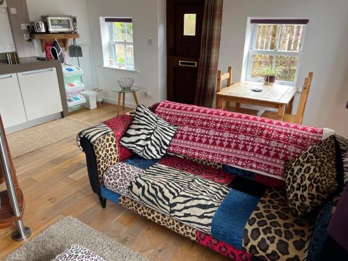 a living room with a couch with a blanket on it at Willow Mews in Swansea
