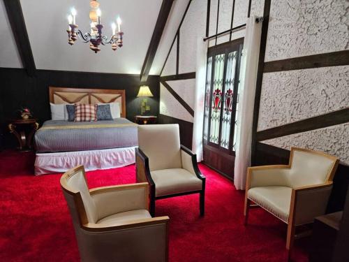 1 dormitorio con 1 cama, 2 sillas y lámpara de araña en Grand Tudor Mansion with Pool near Germantown, en Memphis