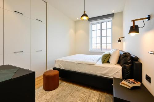 een kleine slaapkamer met een bed en een raam bij 12B, Luxe Designer Oase ~ Historisch Centrum ~ Uitzicht in Oisterwijk