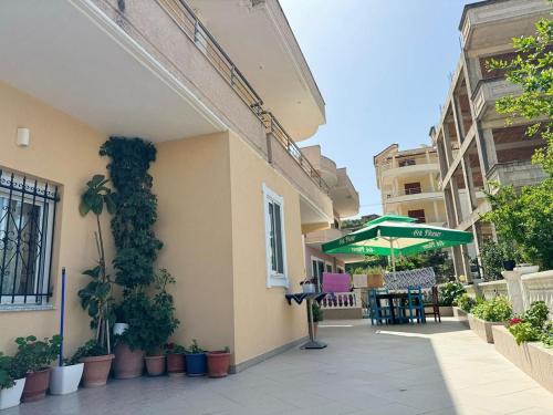 an outdoor patio with a table and an umbrella at Amel's Apartments Comfortable Family Stay Near Orikum Beach in Orikum