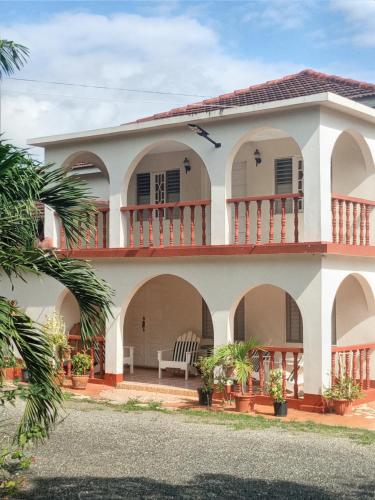 uma grande casa branca com uma varanda em BONI CHATEAU VACATION SPOT is a One Bedroom Self-contained Apartment For Travelers Needing To Be In Tune With Nature em Discovery Bay