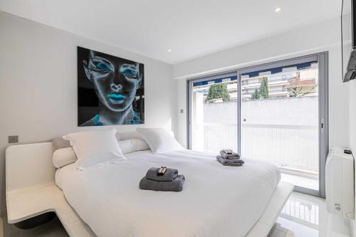 1 dormitorio con cama blanca y ventana grande en Beautiful 2P apartment with sunny terrace, en Cannes
