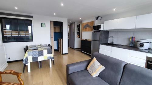 une cuisine et un salon avec un canapé et une table dans l'établissement Détente au gré des marées, à Berck-sur-Mer