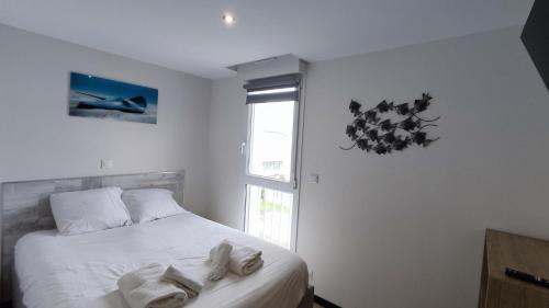 une chambre avec un lit avec des draps blancs et une fenêtre dans l'établissement Détente au gré des marées, à Berck-sur-Mer