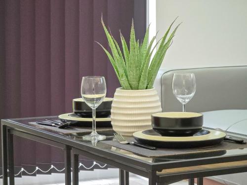 een tafel met twee glazen en een vaas met een plant bij DYSA Bond Apartments in Blackpool