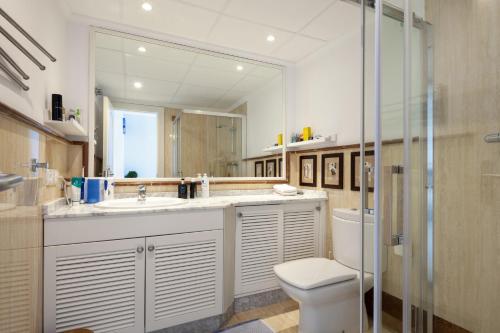 a bathroom with a sink and a toilet and a mirror at Casa adosada en primera línea de playa, Estepona in Estepona