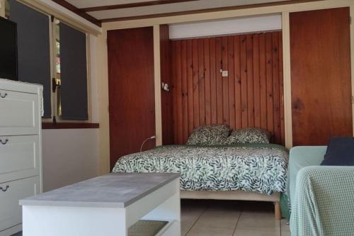 une chambre avec un lit et un mur en bois dans l'établissement appartement indépendant proche circuit 24h, 1 chambre, à Arnage