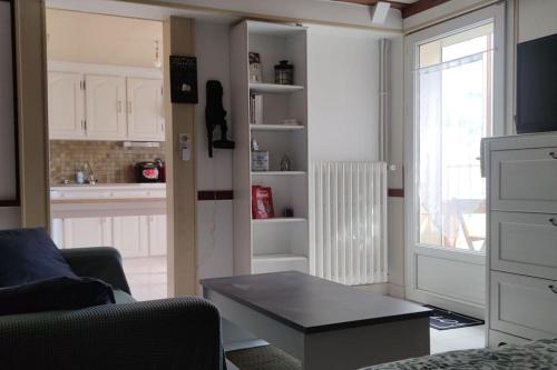 un salon avec une table et une cuisine dans l'établissement appartement indépendant proche circuit 24h, 1 chambre, à Arnage