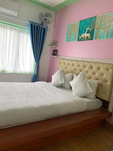 a bedroom with a large bed with white pillows at Mio Hotel in Hải Dương