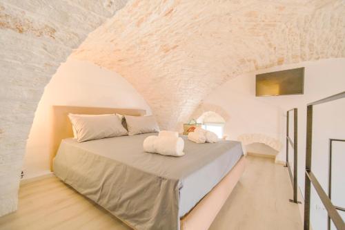 a bedroom with a large bed in a stone wall at Palazzo Gentile in Locorotondo