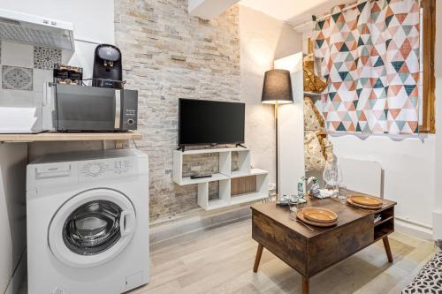 uma lavandaria com uma máquina de lavar roupa e uma televisão em 1 - Historic Center - 200m from the Cathedra em Béziers