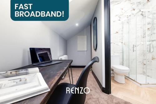 德比的住宿－Inviting 2-bed Apartment in Derby by Renzo, Free Parking, Newly Refurbished!，坐在浴室书桌上的笔记本电脑