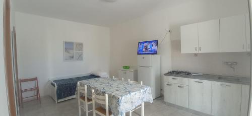 eine kleine Küche mit einem Tisch und einem Bett in der Unterkunft Casa Vacanze Villa Francesca in Peschici