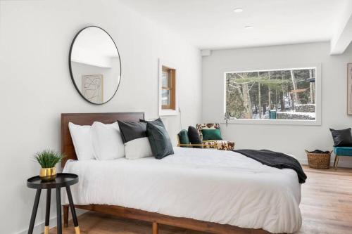 a bedroom with a large bed and a mirror at Hudson Valley and The Berkshires Cottage in Hillsdale