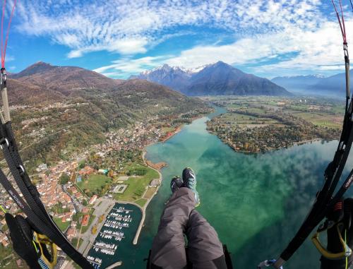 a person flying a glider over a lake at Hotel Europa - Sorico in Sorico