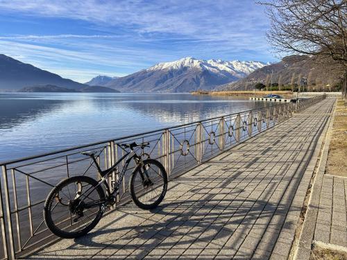 a bike parked on a boardwalk next to a body of water at Hotel Europa - Sorico in Sorico