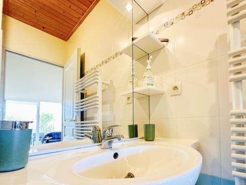 une salle de bain avec un lavabo et un miroir dans l'établissement Maison mitoyenne au calme quartier de la Marcelliere, à Les Sables-dʼOlonne