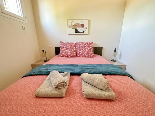 une chambre avec un lit avec deux serviettes dessus dans l'établissement Maison mitoyenne au calme quartier de la Marcelliere, à Les Sables-dʼOlonne