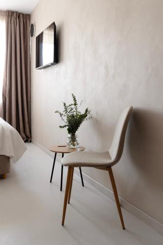 a chair and a table with a vase of flowers at Regal Hotel Mitropoleos in Athens