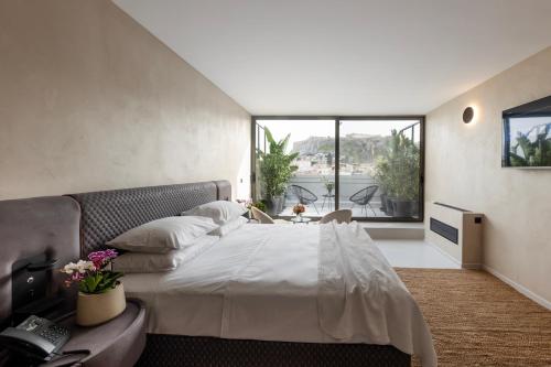 a bedroom with a large bed and a large window at Regal Hotel Mitropoleos in Athens