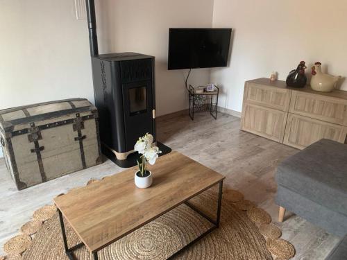 a living room with a coffee table and a tv at La maison du lavoir in Fain-lès-Montbard