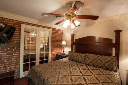 a bedroom with a bed and a ceiling fan at Quarter House Suites in New Orleans