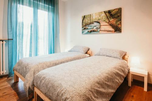 - une chambre avec 2 lits et un tableau mural dans l'établissement Da Mario - Lakeside SRL Leisure & Business, à Arona