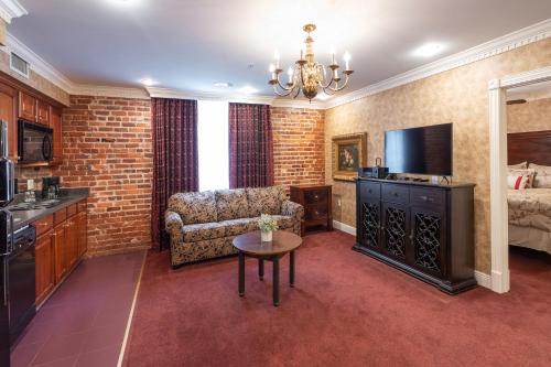 a living room with a couch chair and a television at Quarter House Suites in New Orleans
