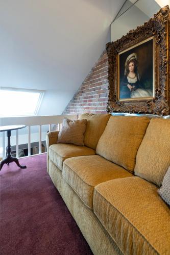 a couch in a room with a painting on the wall at Quarter House Suites in New Orleans