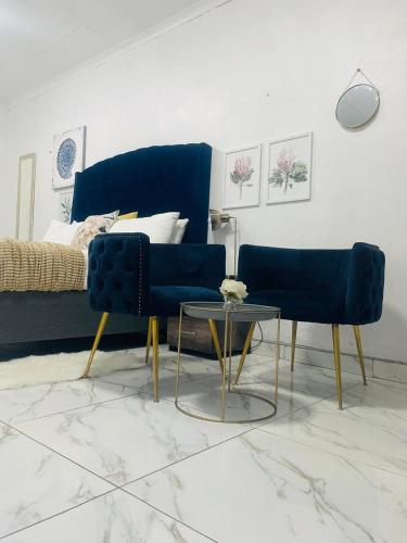 a living room with two blue chairs and a table at The Bliss Boutique in Louis Trichardt