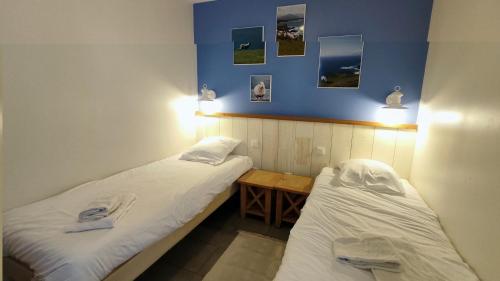 2 camas en una habitación con una mesa y cuadros en la pared en Argousiers 8 en Fort-Mahon-Plage