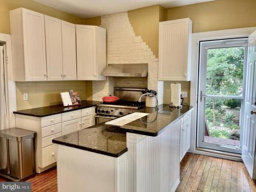 a kitchen with white cabinets and black counter tops at Vintage Charm: Annapolis Retreat in Annapolis